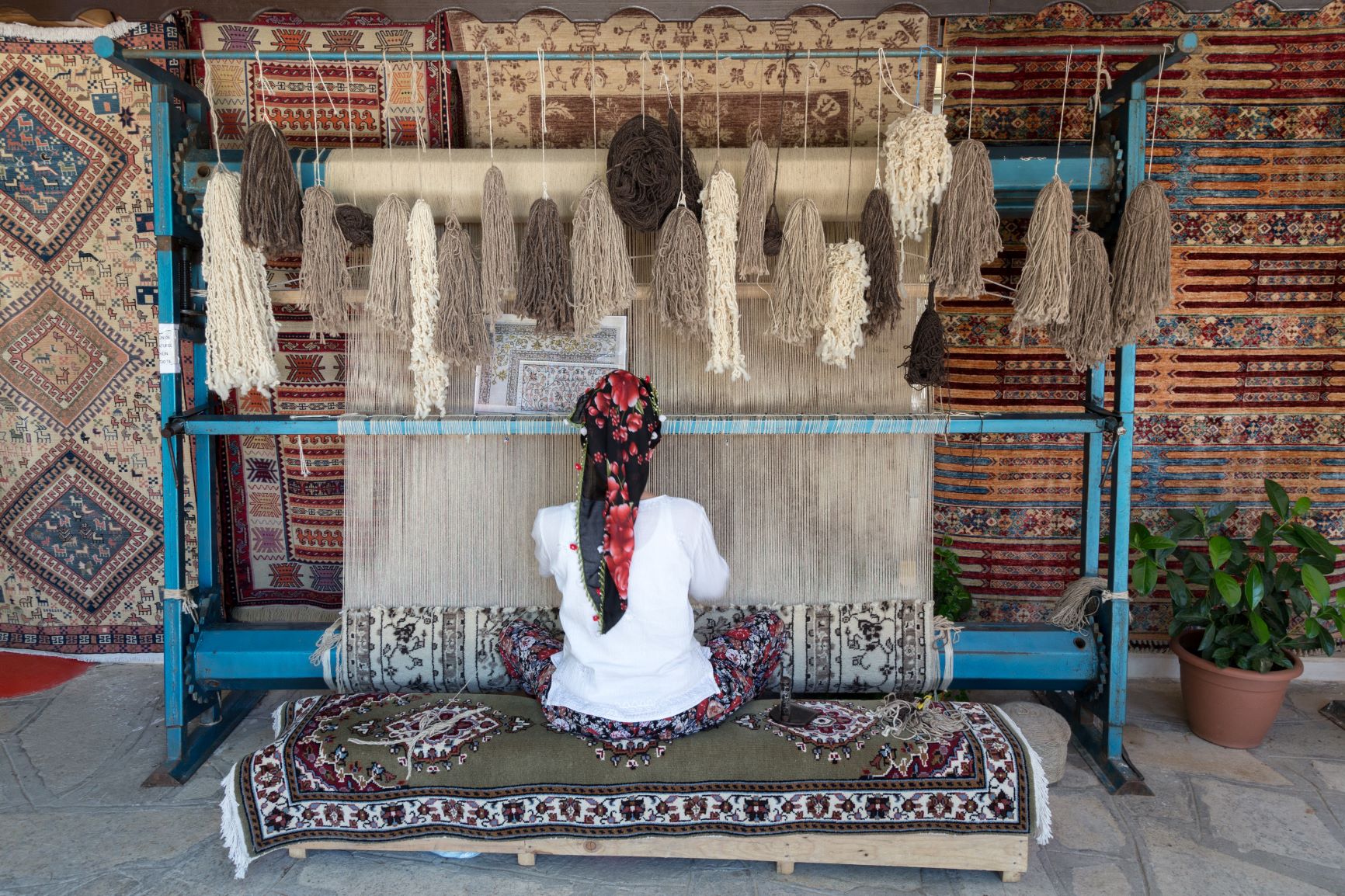 persian woman knotting a rug